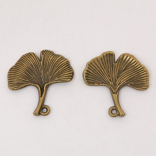 Ginkgo Leaf-Shaped Metal Charm Pendants shown in a angled detail view on a plain background