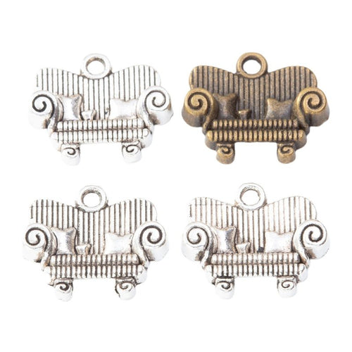 Front and reverse details of ornate sofa charms on a white background