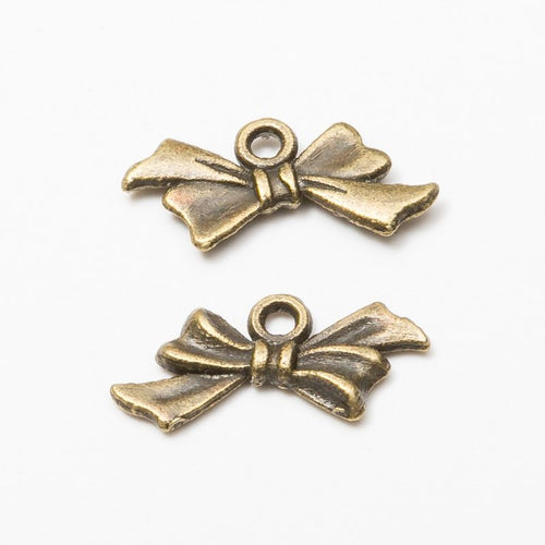 Front and reverse views of the tied ribbon bow metal charms in two antique finishes
