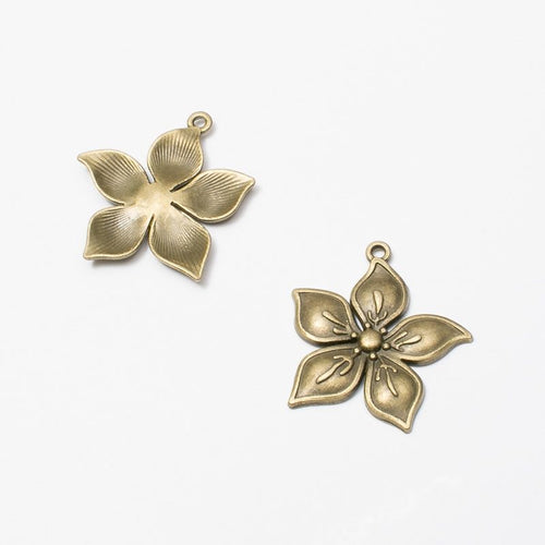 Close product view of the layered five petal flower charm in two antique finishes