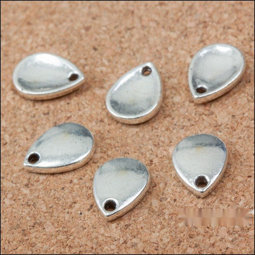 Close-up view of the smooth teardrop metal charms in antique silver showing its front and reverse metal details.