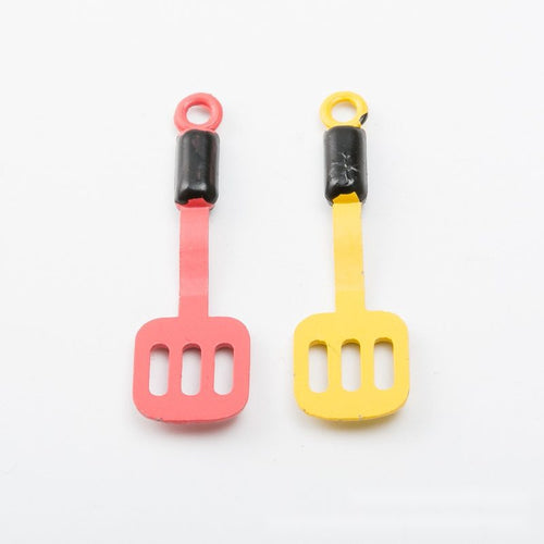 Alternate image of slotted spatula charm showing available finishes and form