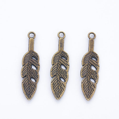 Product photo 2 of the openwork feather charm highlighting its slender feather with open barbs and a top loop