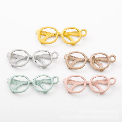 Close product view showing the front and reverse details of the eyeglasses charm