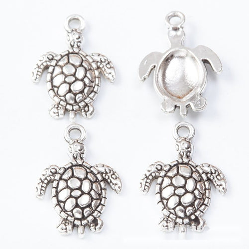 Turtle connectors with open filigree shells and lower loops shown from the front on a white background.