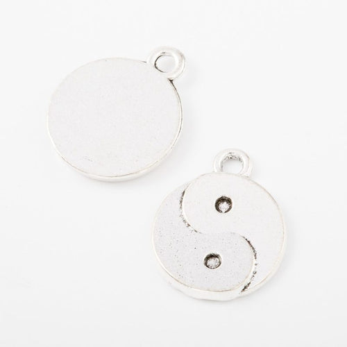 Close view showing the front and reverse details of the round yin yang charm