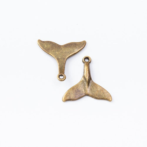 Small Whale Tail Charm in an antique tone shown from the front
