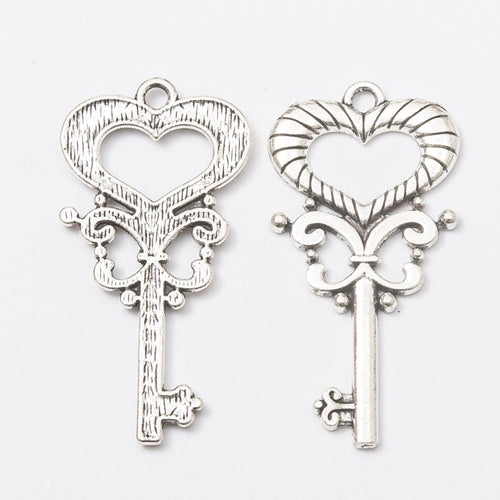 Close-up view of the open heart skeleton key metal charms in three finishes showing its front and reverse metal details.