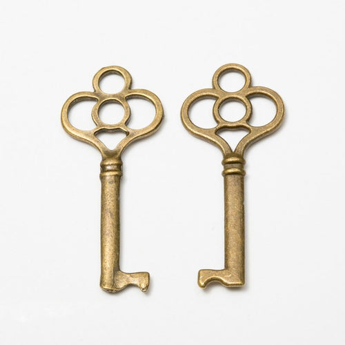 Close front view of skeleton key charm showing a four-loop bow, ribbed neck, and short bit