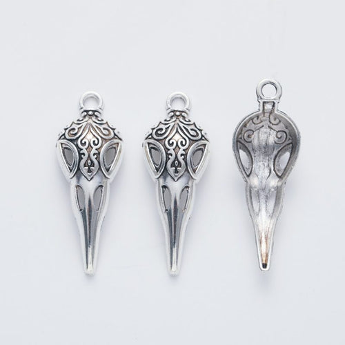 Close view showing the front and reverse details of the ornate bird skull charm
