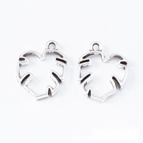 Closer product view of open monstera leaf bezel charm shown against a plain background.