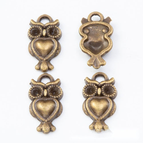 Front and reverse views of the heart belly owl metal charms in two antique finishes