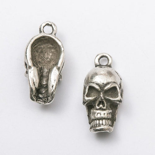 Close view of the relief and openwork details on the long skull head metal charm