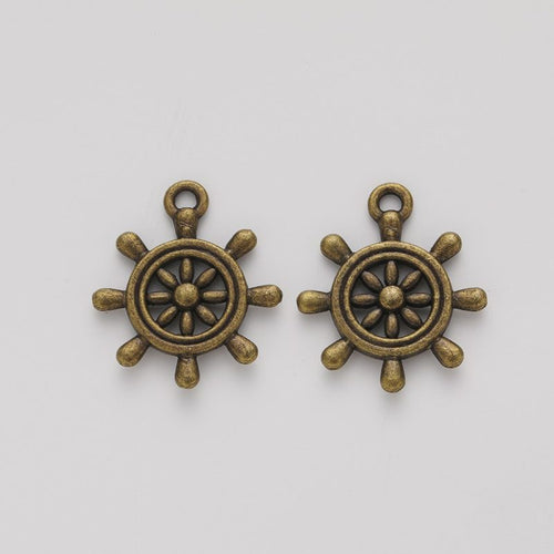 Close view showing the front and reverse details of the ship wheel charm