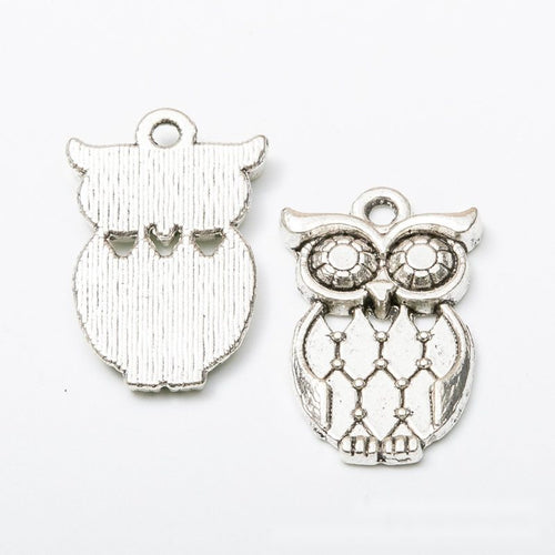 Angled detail views of openwork owl charms