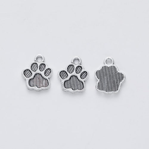Close front and reverse view of the metal paw-print charm