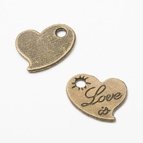 Close product view of the engraved love heart metal charm in two antique finishes