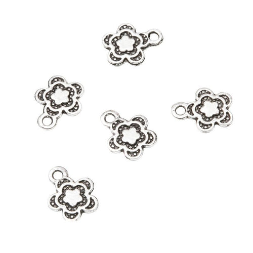 Front detail of tiny five-petal flower outline with dark recessed accents