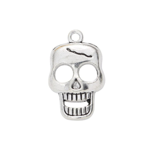 Close view of the relief and openwork details on the smiling skull metal charm