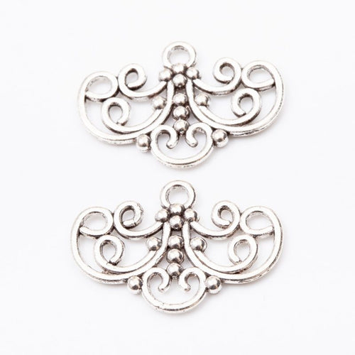 Close view of the three-loop scroll connector showing curled filigree and three lower attachment loops