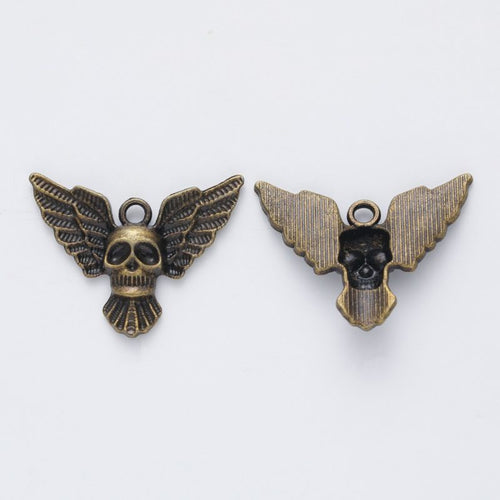 Close view of the relief and openwork details on the winged skull metal charm
