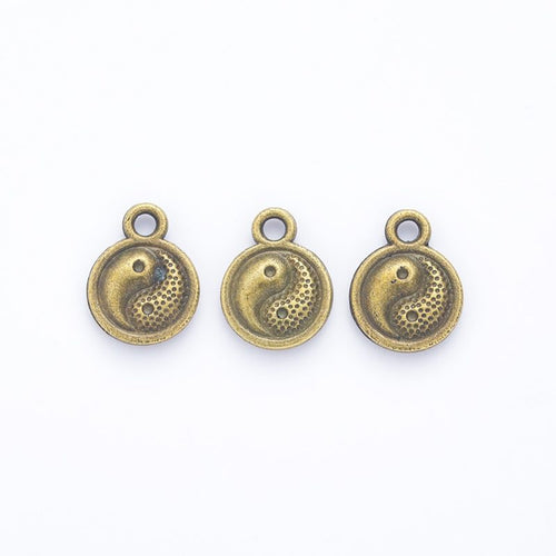 Front and reverse views of the round yin yang charm