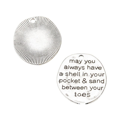 Close-up view of the round pocket and sand quote metal charm showing its front and reverse metal details.