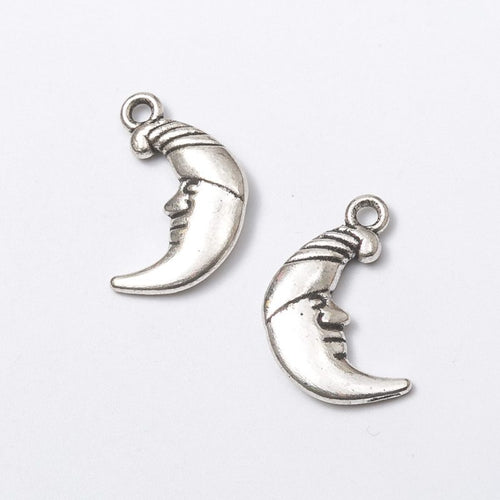 Front and reverse details of crescent moon face charms on a white background