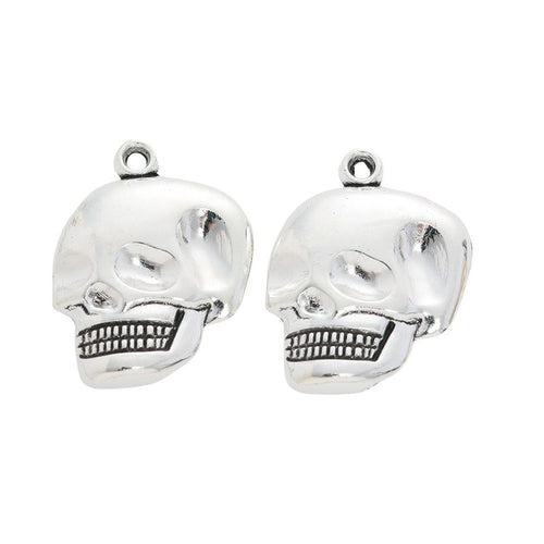 Grouped view of the grinning skull head metal charm from the front