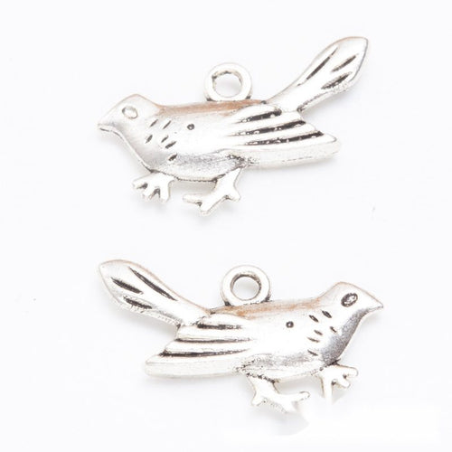 Close product view showing the front and reverse details of the flying bird charm