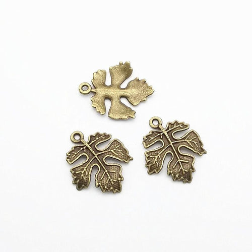 Close front and reverse view of the metal maple leaf charm