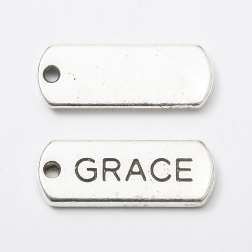 Close view of the relief and openwork details on the grace rectangular message tag charm
