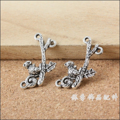 Close product view of the squirrel on branch multi loop silver tone connector charm