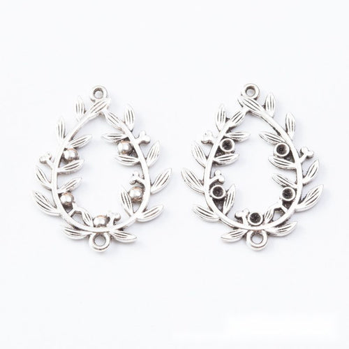Ornate teardrop connectors with raised leaf scrollwork shown from the front on a white background.