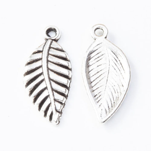 Close product view of the veined leaf metal charm in three metallic finishes