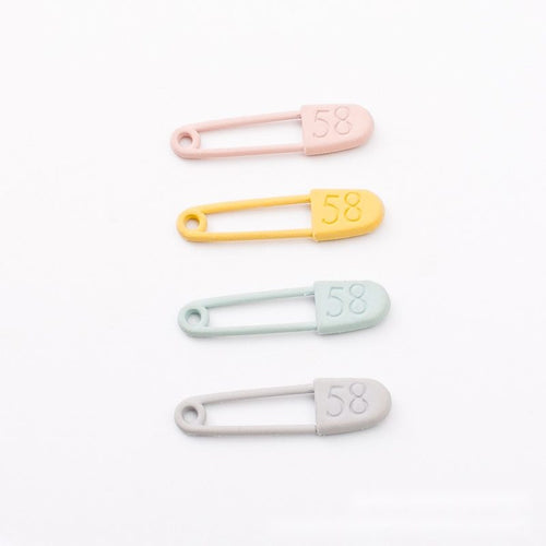 Closer view of the slender safety pin with a rounded numbered cover