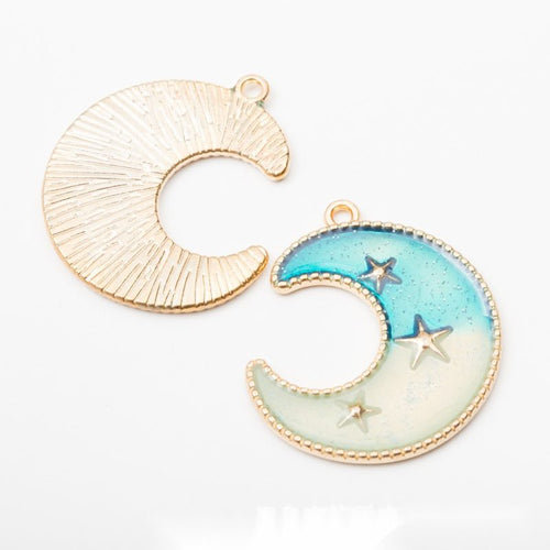 Close view of the ten celestial charm designs featuring moons, stars, and ringed planets with glossy enamel