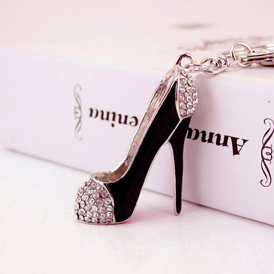 Close-up of a black high heel shoe charm with clear stones on the toe and heel.