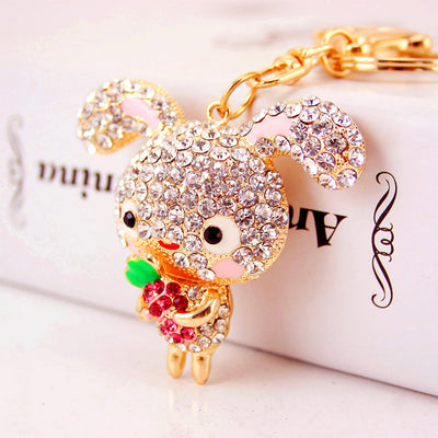 Close-up of a clear rhinestone rabbit holding a pink rhinestone carrot.