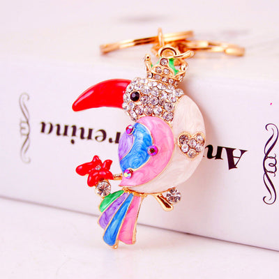 Close-up of a crowned parrot charm with a red beak and multicolor feather details.