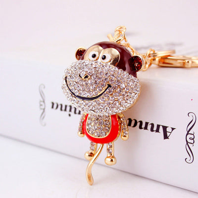 Close-up of a red-bellied monkey keychain covered with clear rhinestones.