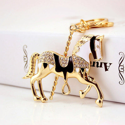 Black and white carousel horse keychain with clear faceted accents shown from the front.
