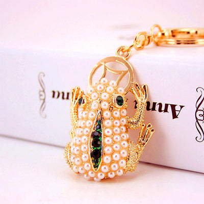 Close-up of a white beaded frog charm with green stone accents.