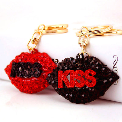 Red and black faceted lips keychains rest side by side with contrasting KISS lettering.