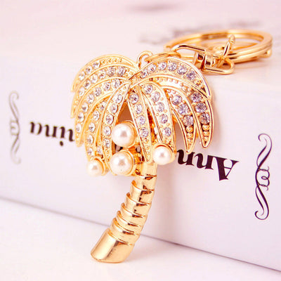 Close-up of the gold-tone palm tree charm with clear stones and white beads.