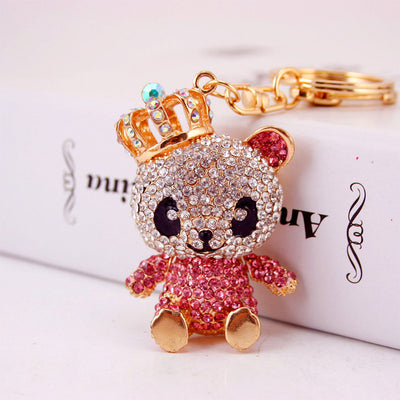 A pink rhinestone panda charm wearing a gold-tone crown beside a split key ring.