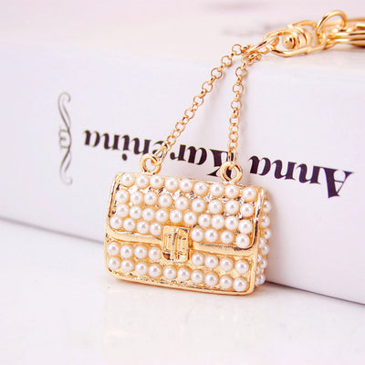Close-up of the beaded handbag charm showing its chain handle and front clasp detail.