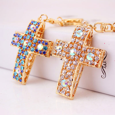 Blue and white rhinestone cross charms shown together on a pale background.