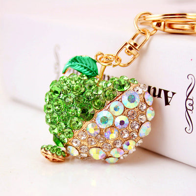 Green rhinestone apple keychain shown beside a white box.