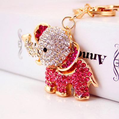 Close-up of a pink rhinestone elephant attached to a gold-tone keychain.